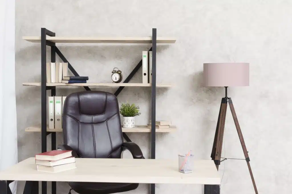 A brown chair behind a light brown desk. 