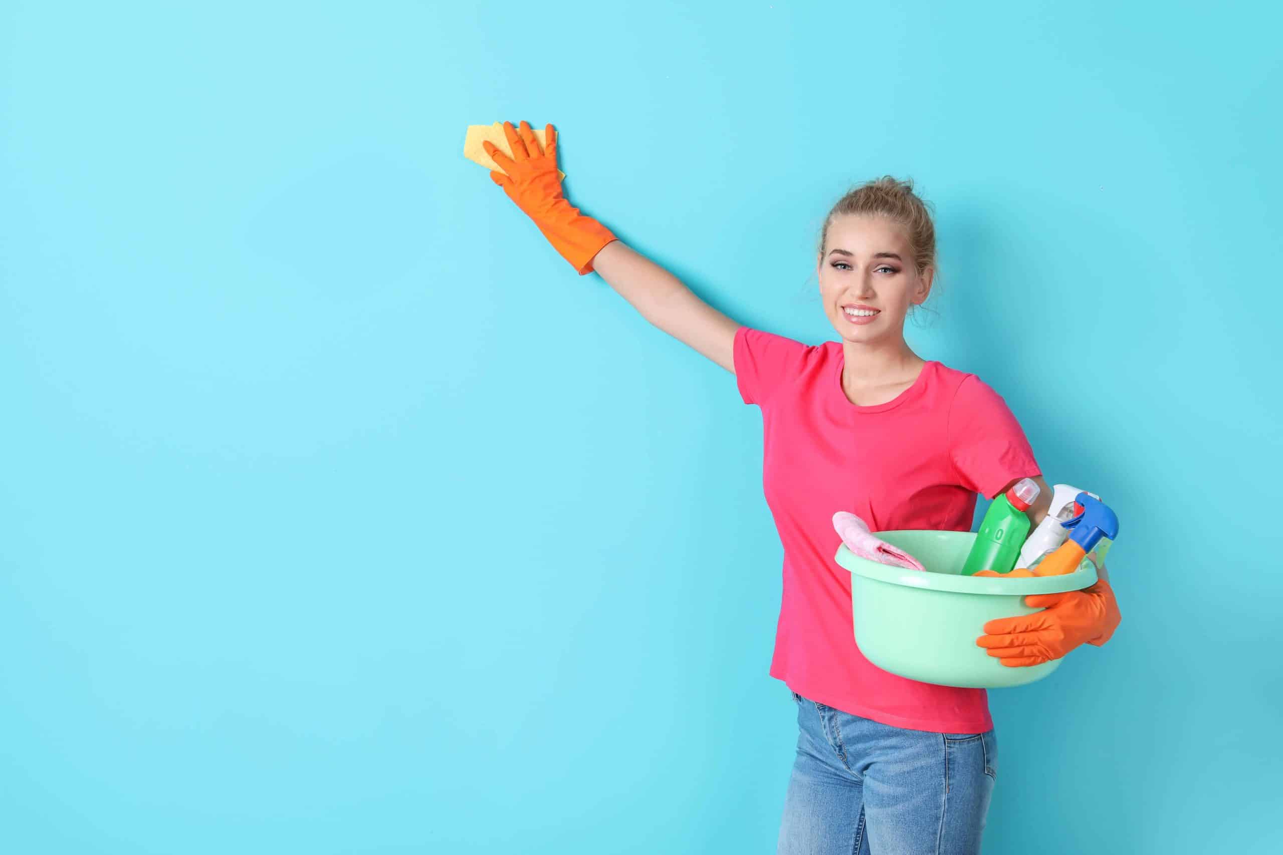 Woman in a red t-shirt cleaning a blue wall