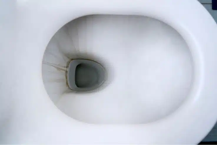an inside look into a hard water stained white porcelain toilet bowl