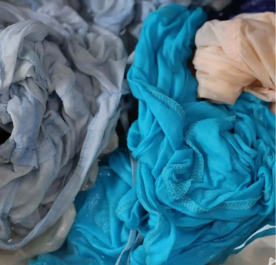 assorted coloured damp clothes in a top loader washing machine