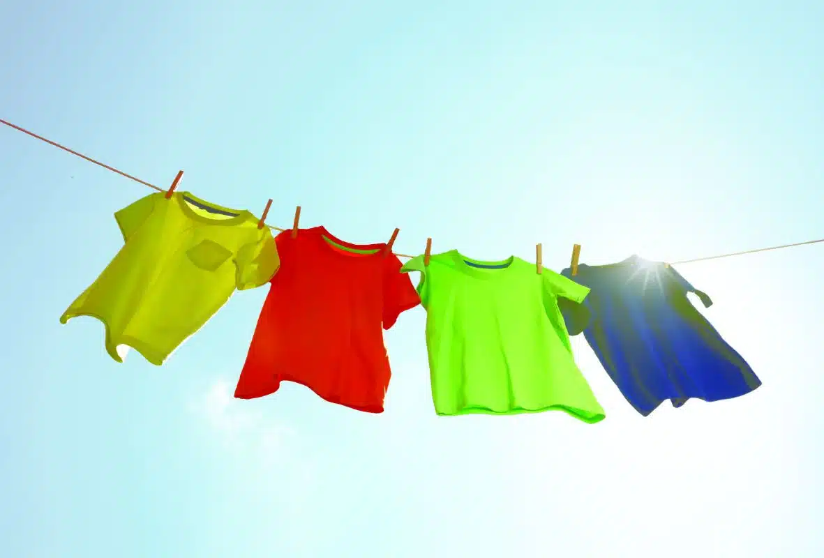 four assorted coloured t-shirts hanging on a clothes line