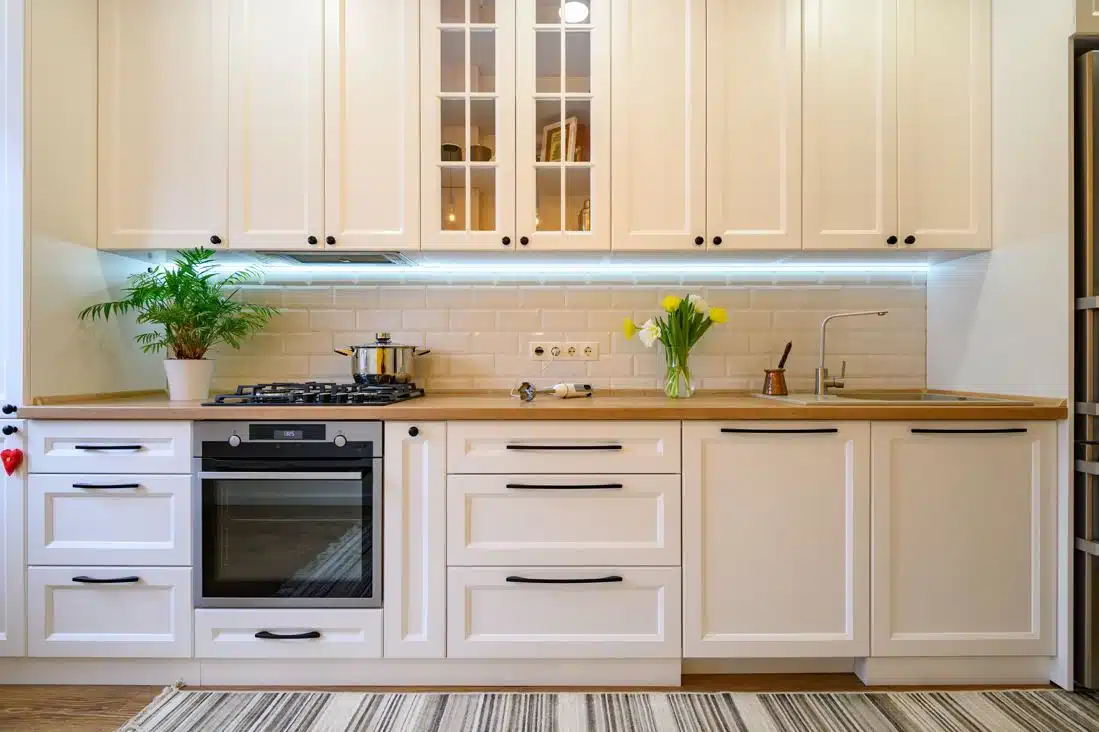 clean decluttered modern kitchen with tall wooden kitchen cabinets